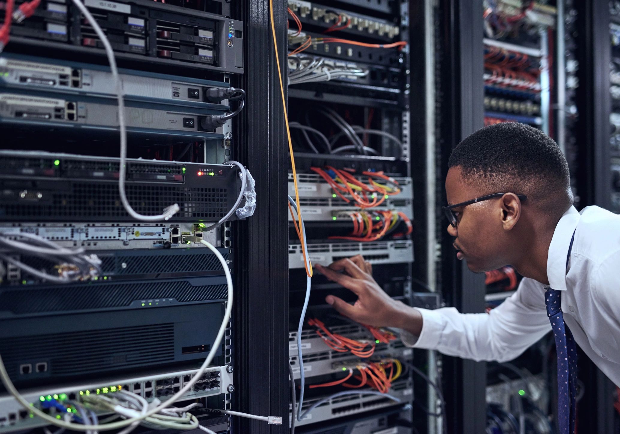 IT technician checking network equipment in a server room